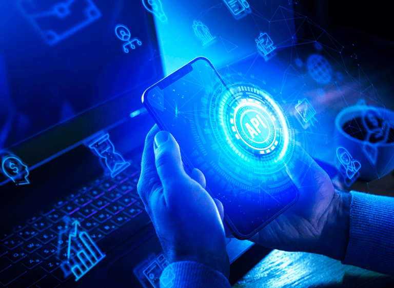 laptop and man holding cellphone with an API visual